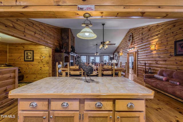 kitchen with lofted ceiling, ceiling fan, wood-type flooring, and tile countertops