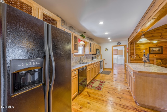 kitchen featuring black appliances, light wood-type flooring, sink, tile counters, and backsplash