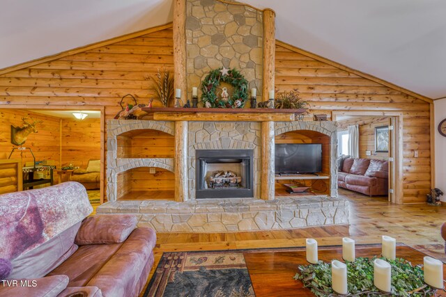 living room with high vaulted ceiling, a fireplace, hardwood / wood-style flooring, and log walls