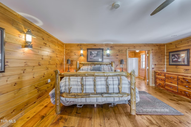 bedroom with wood-type flooring and wooden walls