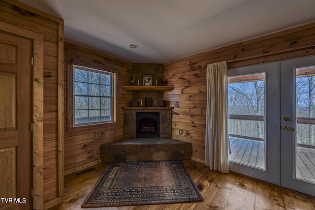 interior space with a fireplace, french doors, and light hardwood / wood-style floors