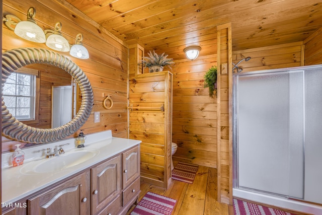 bathroom featuring vanity, hardwood / wood-style floors, wood walls, toilet, and wood ceiling