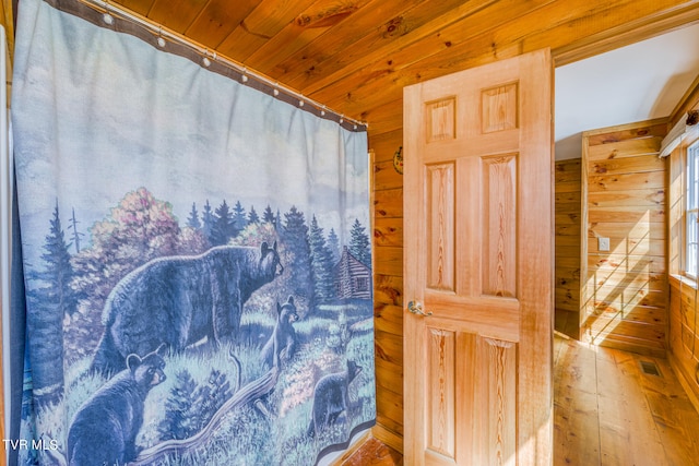 bathroom with wood walls, hardwood / wood-style floors, and wood ceiling