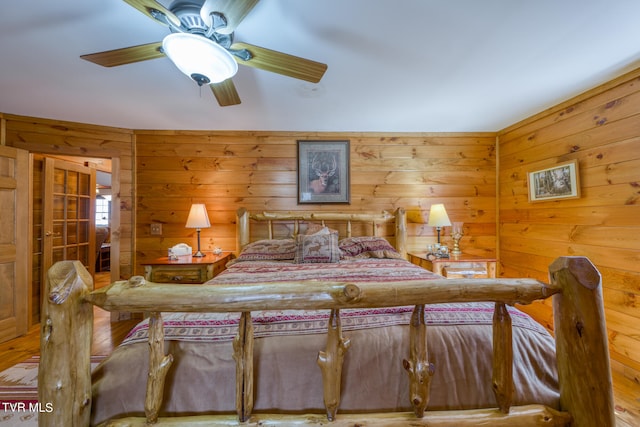 bedroom with wood walls and ceiling fan