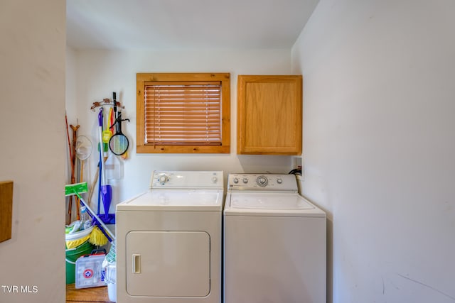 clothes washing area featuring washer and clothes dryer and cabinets