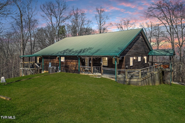 view of front of property with central AC and a lawn