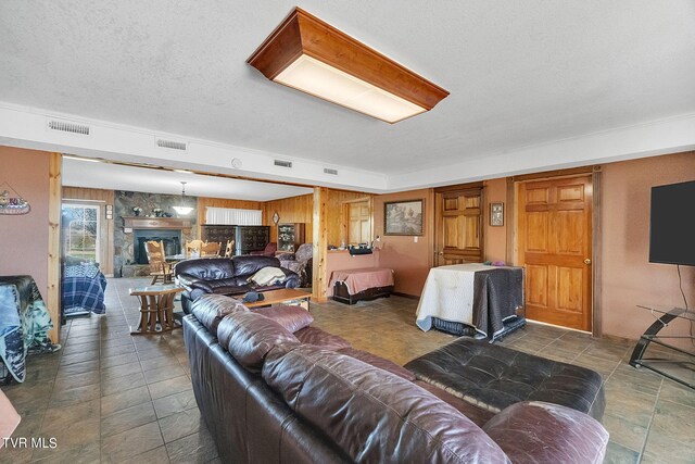 545 Mcmillian Rd, Midway, TN 37809 - living room featuring a textured ceiling, dark tile floors, and a stone fireplace