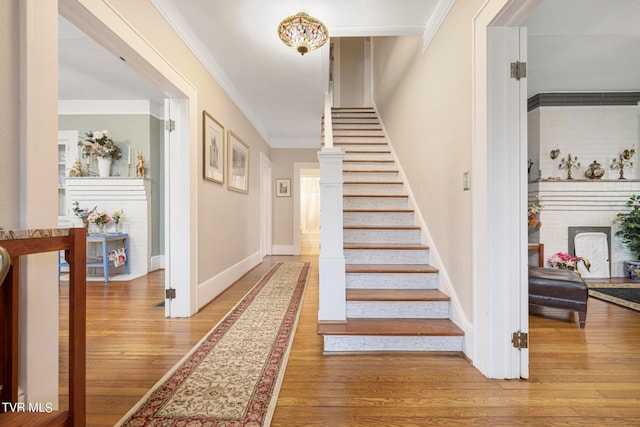 stairs featuring light hardwood / wood-style flooring and ornamental molding