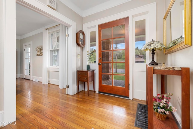 entryway with crown molding and light wood-type flooring