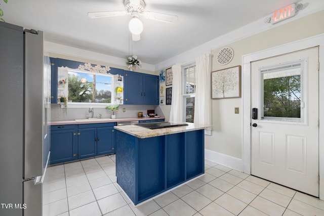 kitchen with plenty of natural light, tasteful backsplash, stainless steel fridge, and ceiling fan