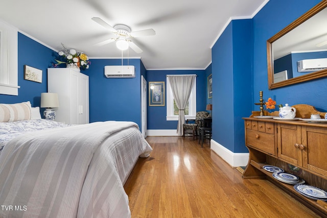 bedroom with a wall mounted air conditioner, ceiling fan, and light wood-type flooring