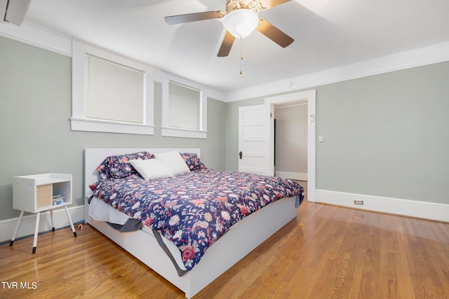 bedroom with ceiling fan, ornamental molding, and light hardwood / wood-style floors