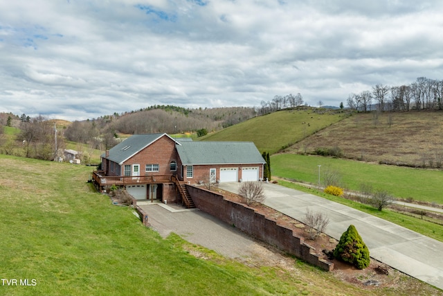 exterior space featuring a front lawn, a rural view, and a garage