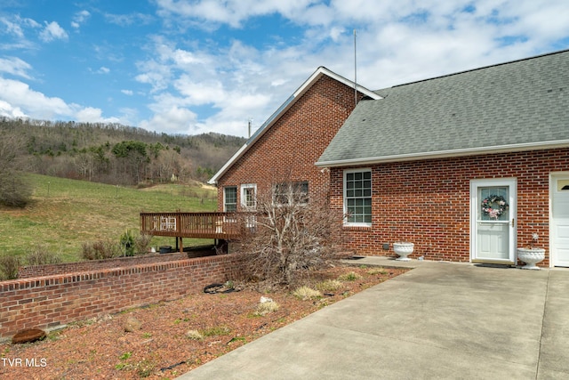 view of side of home featuring a deck and a patio area