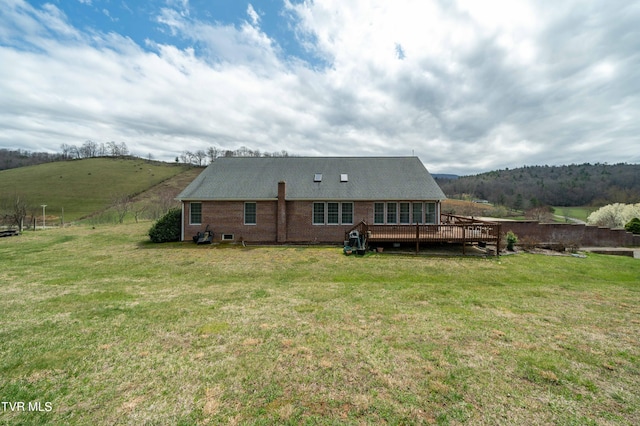 back of house with a deck and a yard