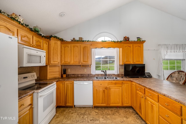 kitchen featuring white appliances, sink, a healthy amount of sunlight, backsplash, and vaulted ceiling