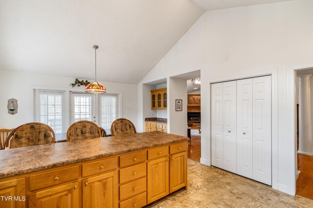 kitchen featuring high vaulted ceiling, hanging light fixtures, and light tile floors