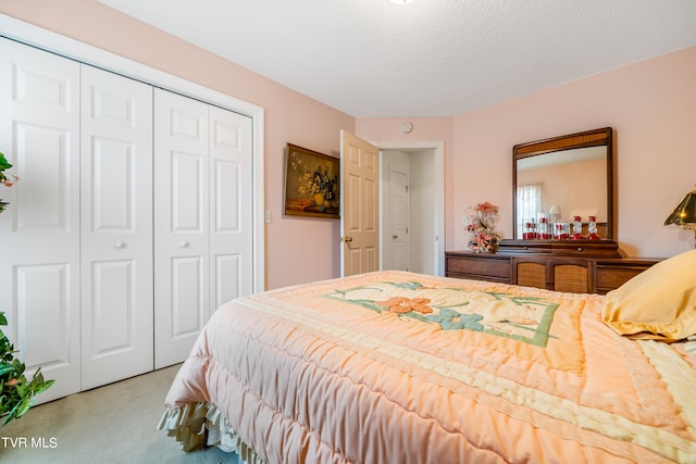 bedroom with a closet, a textured ceiling, and light colored carpet