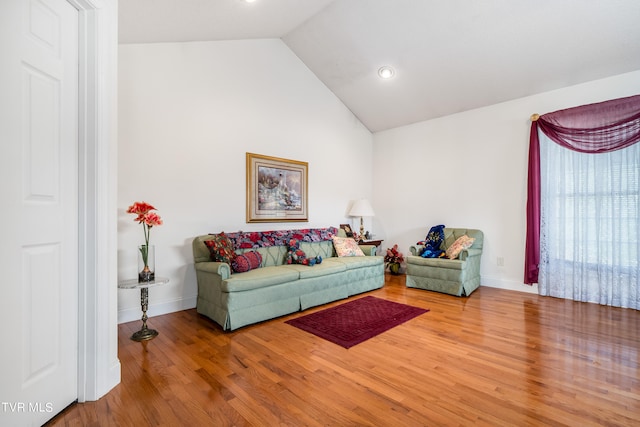 living room with light hardwood / wood-style flooring and vaulted ceiling