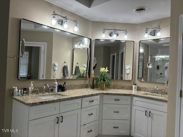 bathroom with a sink, visible vents, and double vanity