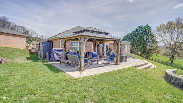 rear view of property featuring brick siding, a gazebo, a yard, and a patio area