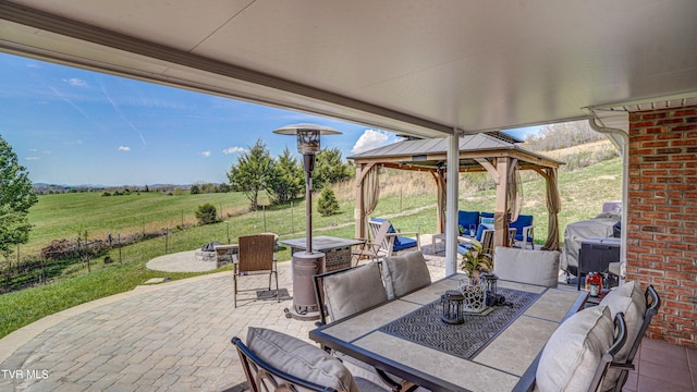 view of patio / terrace with a rural view, an outdoor living space with a fire pit, grilling area, outdoor dining area, and a gazebo