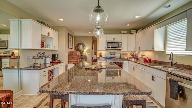 kitchen featuring recessed lighting, white cabinets, a sink, and stainless steel appliances