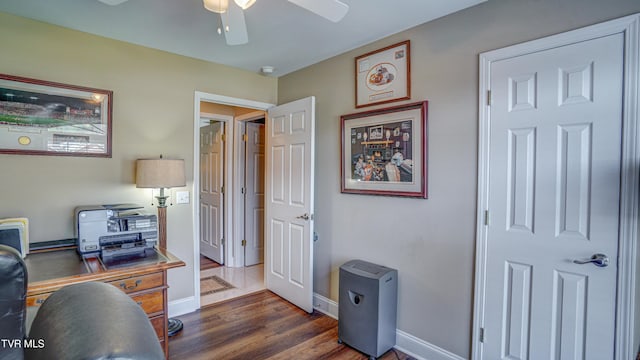 home office with baseboards, a ceiling fan, and dark wood finished floors