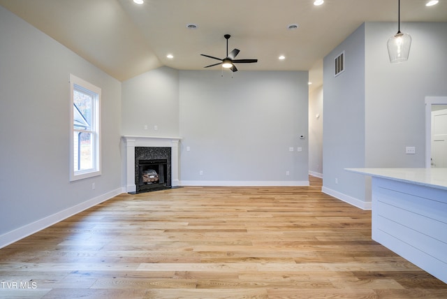 unfurnished living room with lofted ceiling, ceiling fan, and light hardwood / wood-style floors