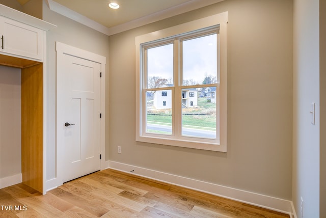 interior space with crown molding and light hardwood / wood-style flooring