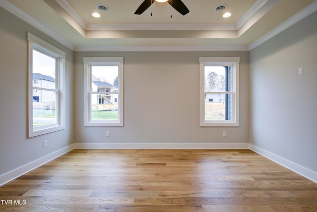 unfurnished room with light wood-type flooring, ceiling fan, and a raised ceiling