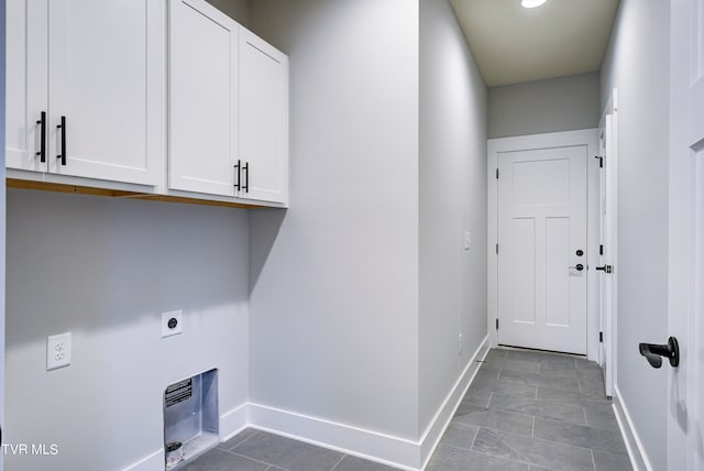 laundry room featuring cabinets, electric dryer hookup, and light tile patterned flooring