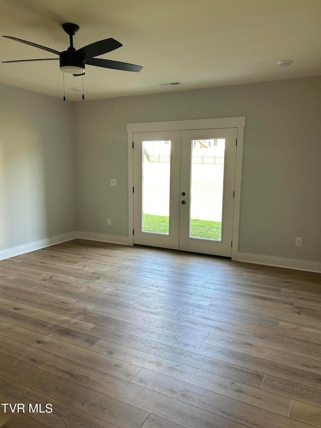 unfurnished room featuring french doors, light hardwood / wood-style flooring, and ceiling fan