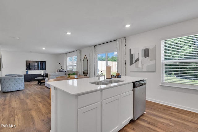 kitchen featuring white cabinets, sink, wood-type flooring, a kitchen island with sink, and stainless steel dishwasher