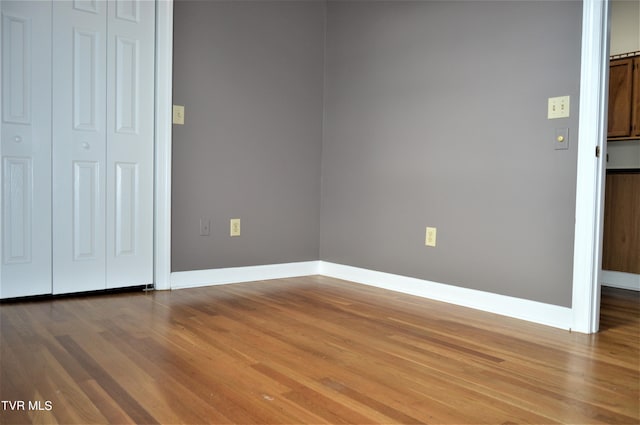 unfurnished bedroom featuring a closet and dark hardwood / wood-style floors