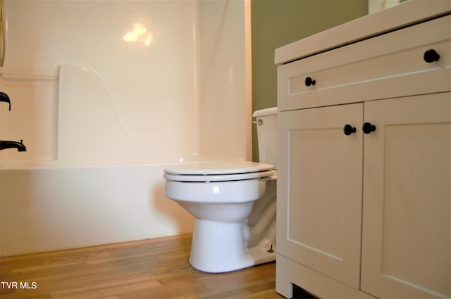 bathroom with hardwood / wood-style floors, toilet, and vanity