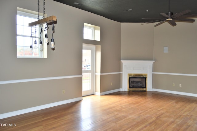 unfurnished living room featuring a wealth of natural light and hardwood / wood-style floors