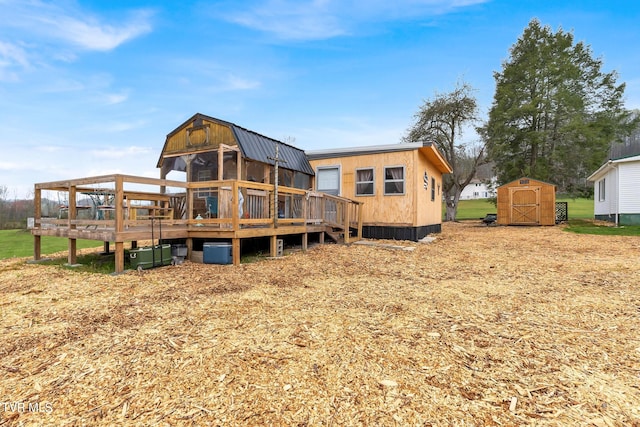 back of property with a shed and a wooden deck