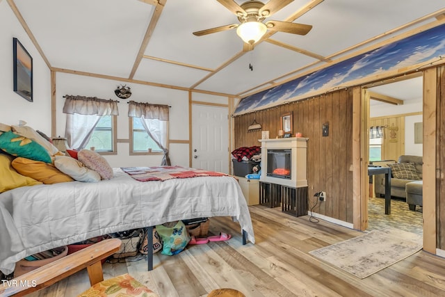 bedroom featuring wooden walls, light wood-type flooring, and ceiling fan