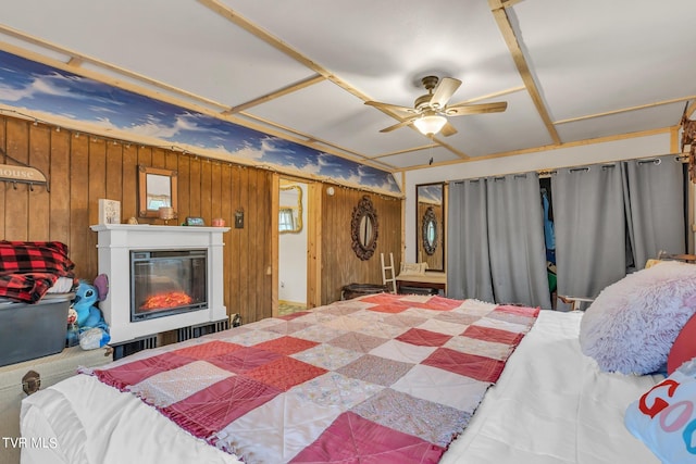 bedroom featuring wood walls, a closet, and ceiling fan