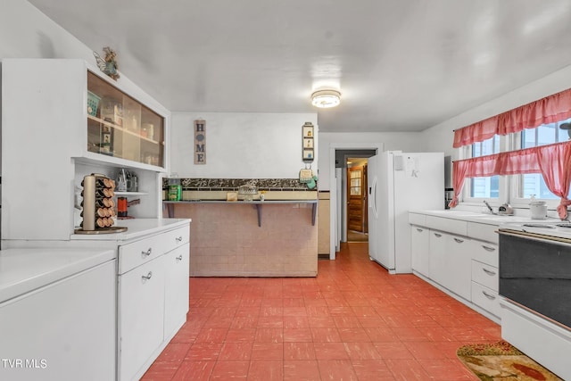 kitchen featuring white cabinets, white appliances, washer / dryer, and light tile floors