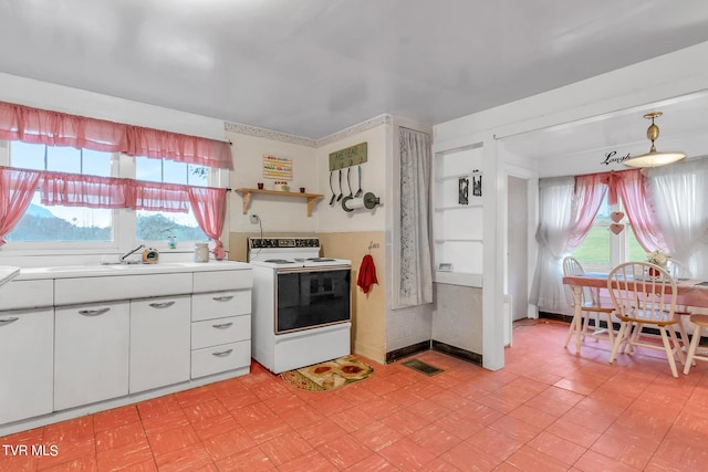 kitchen featuring plenty of natural light, white electric range, and light tile floors