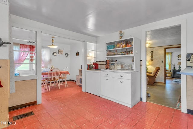 kitchen featuring decorative light fixtures, white cabinetry, and light tile floors