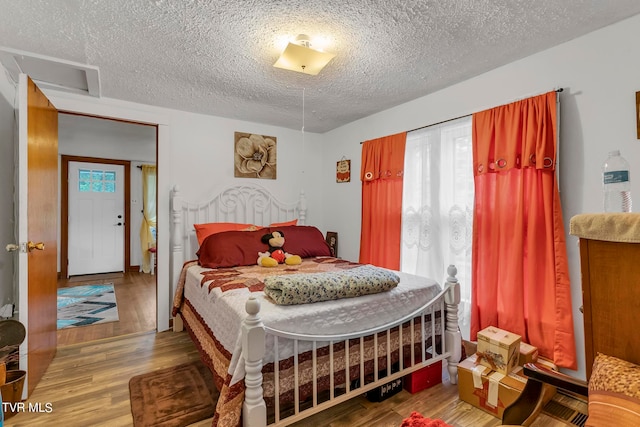 bedroom featuring a textured ceiling and hardwood / wood-style floors