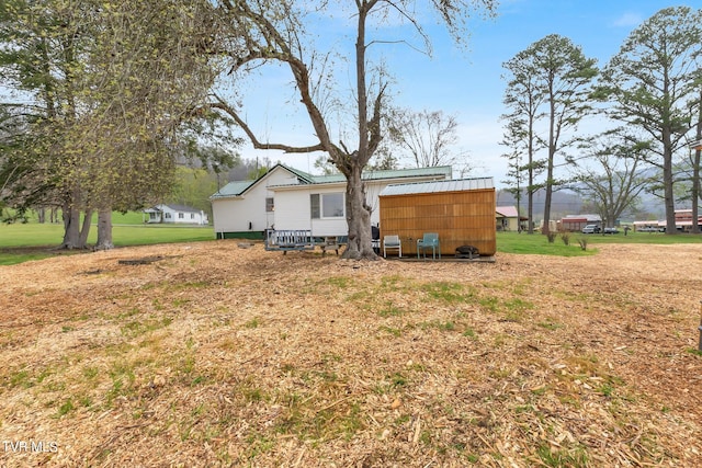 back of house with a yard and an outdoor structure