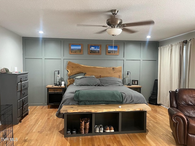 bedroom featuring a textured ceiling, light hardwood / wood-style floors, and ceiling fan