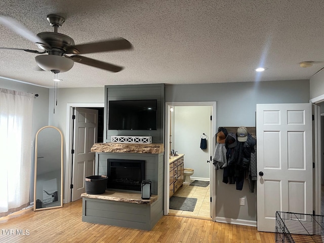 living room with light tile floors, a healthy amount of sunlight, a textured ceiling, and ceiling fan