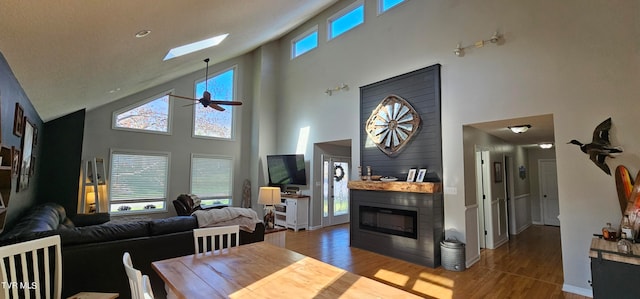 dining area featuring ceiling fan, dark hardwood / wood-style floors, high vaulted ceiling, and a healthy amount of sunlight