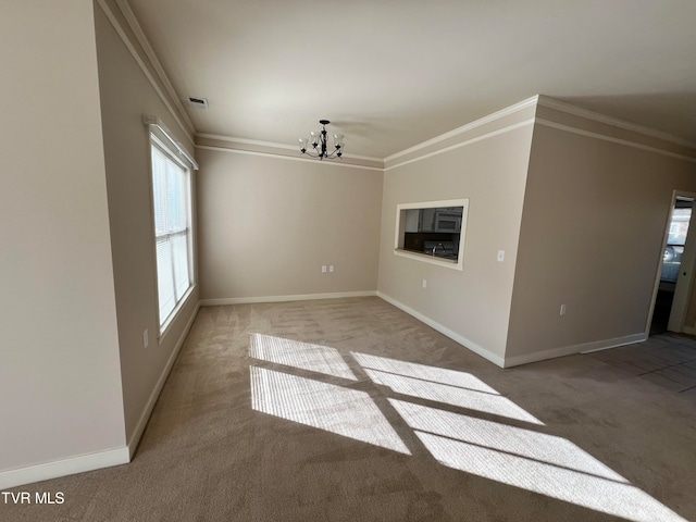 carpeted spare room with a chandelier and ornamental molding