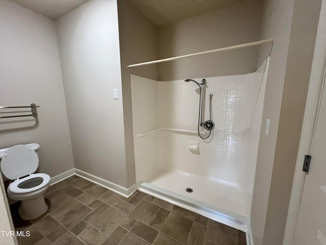 bathroom with tile flooring, walk in shower, and toilet